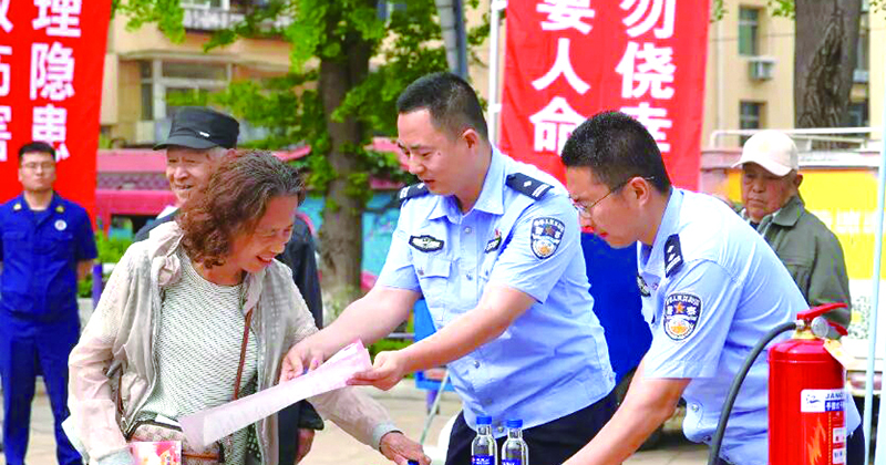 民警向市民发放消防科普手册。 刘文琳 摄