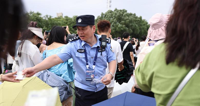 李斌（中）在音乐节现场向群众分发物品，开展现场服务和秩序维护工作