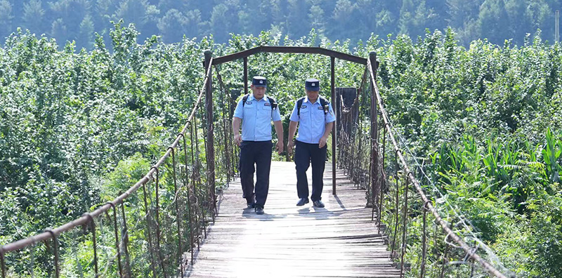 王亚楼（左）与辅警在山村的路上。