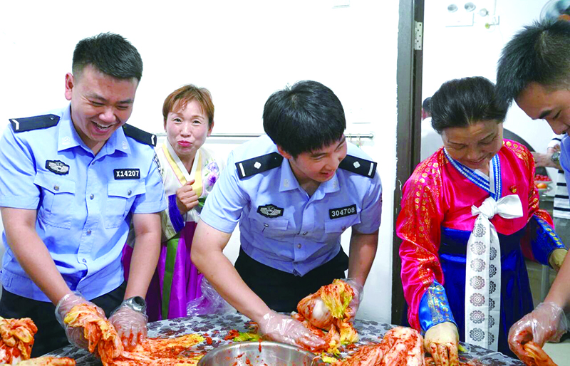 二题图，民警同朝鲜族阿姨一起做辣白菜。