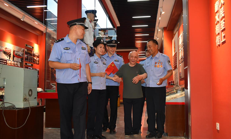 青年民警和盲人群众一同在建设派出所荣誉室聆听翁少波讲述爱民传承故事。陈凯 摄