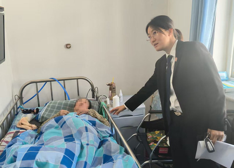 （老人的脸得打码！）3苏家屯区法院林盛法庭王菲法官在办案期间探望老人。